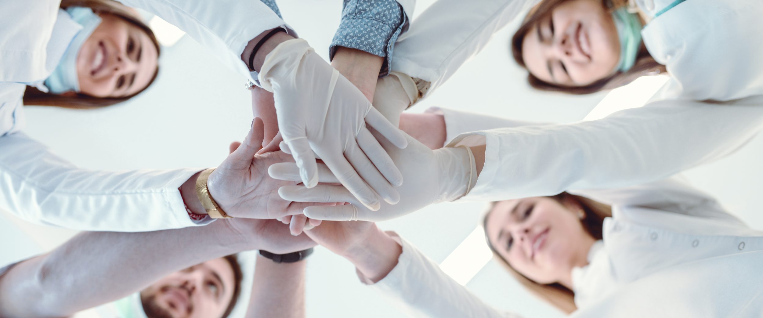 Multiethnic Medical Team Stacking Hands in Circle For Success